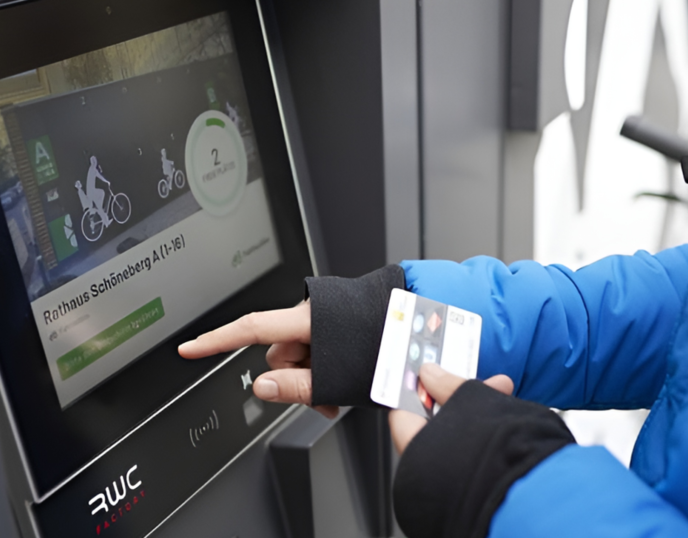 Mensch tippt mit Finger auf ParkYourBike Terminal