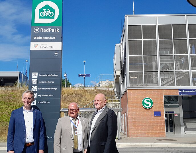 three men in front of the RadPark info column